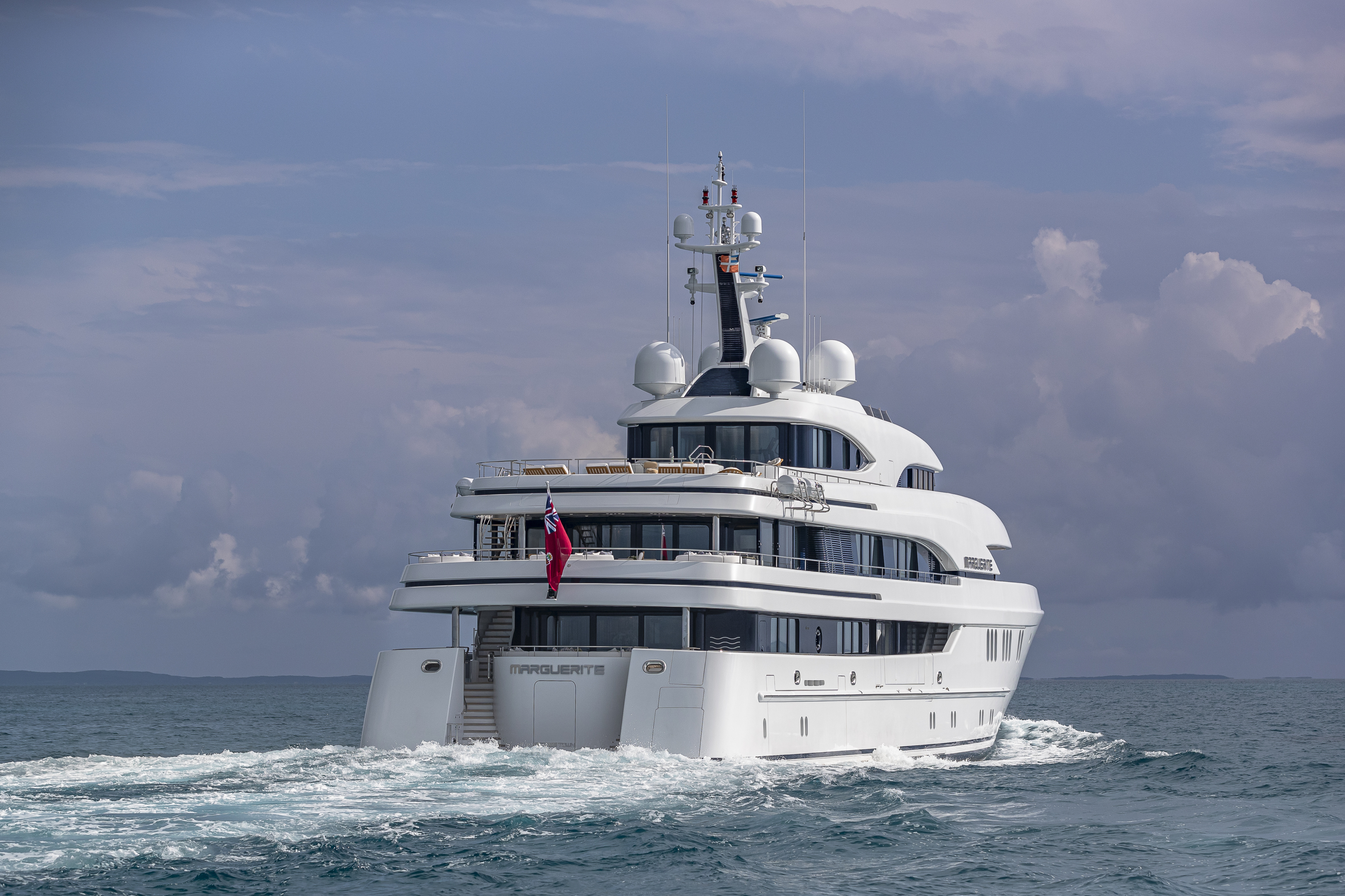 The Back of a Yacht Traveling Through Waters on a Cloudy Day